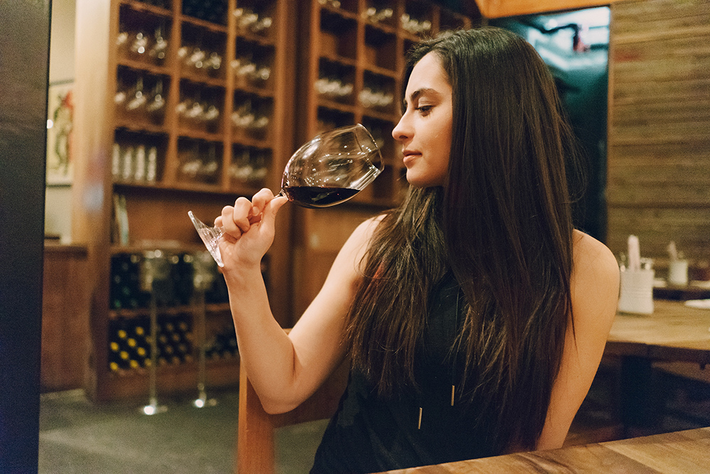 beautiful young girl enjoying delicious wine in a restaurant